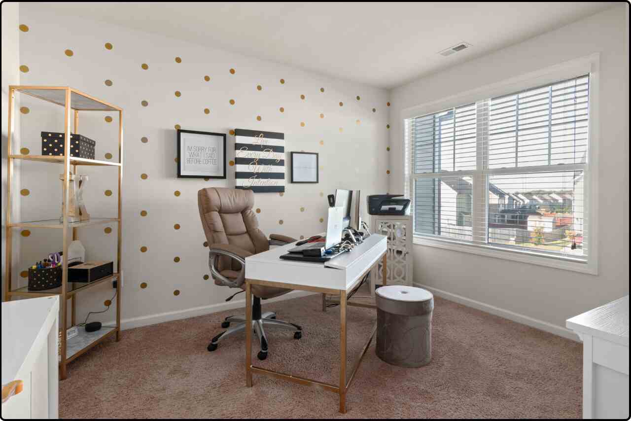 Bright and airy modern home office with a glass desk, comfortable chair, and organized workspace, complemented by modern wall art